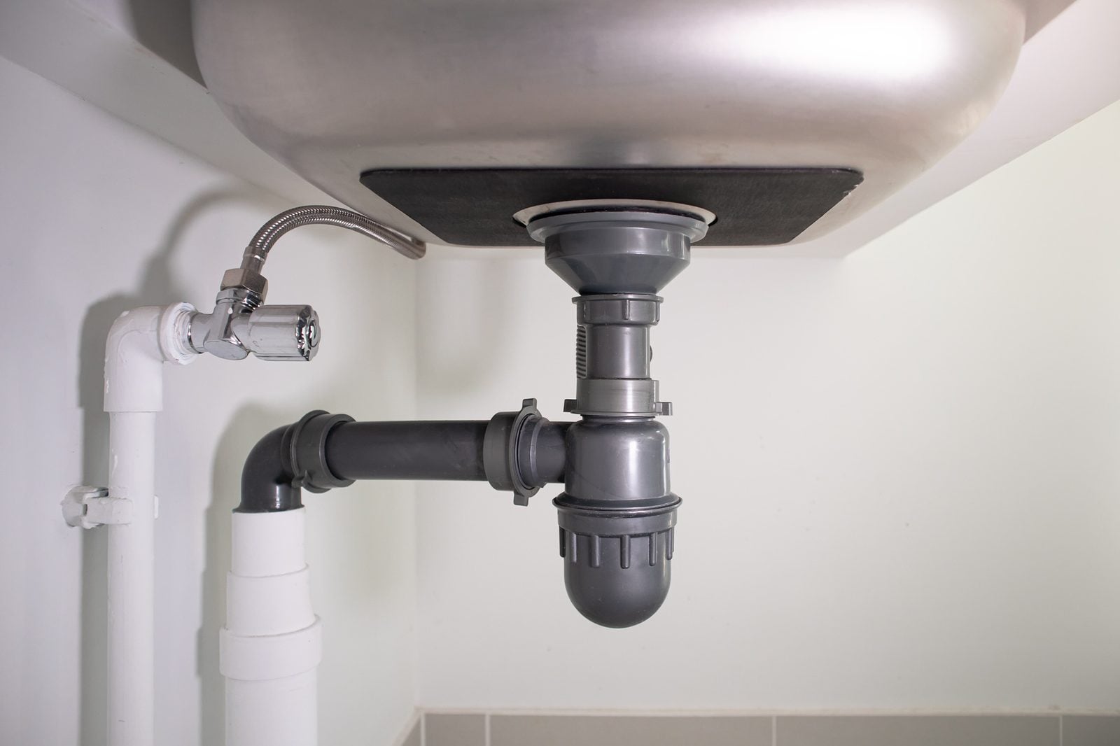 Drain pipe and supply lines under a kitchen sink